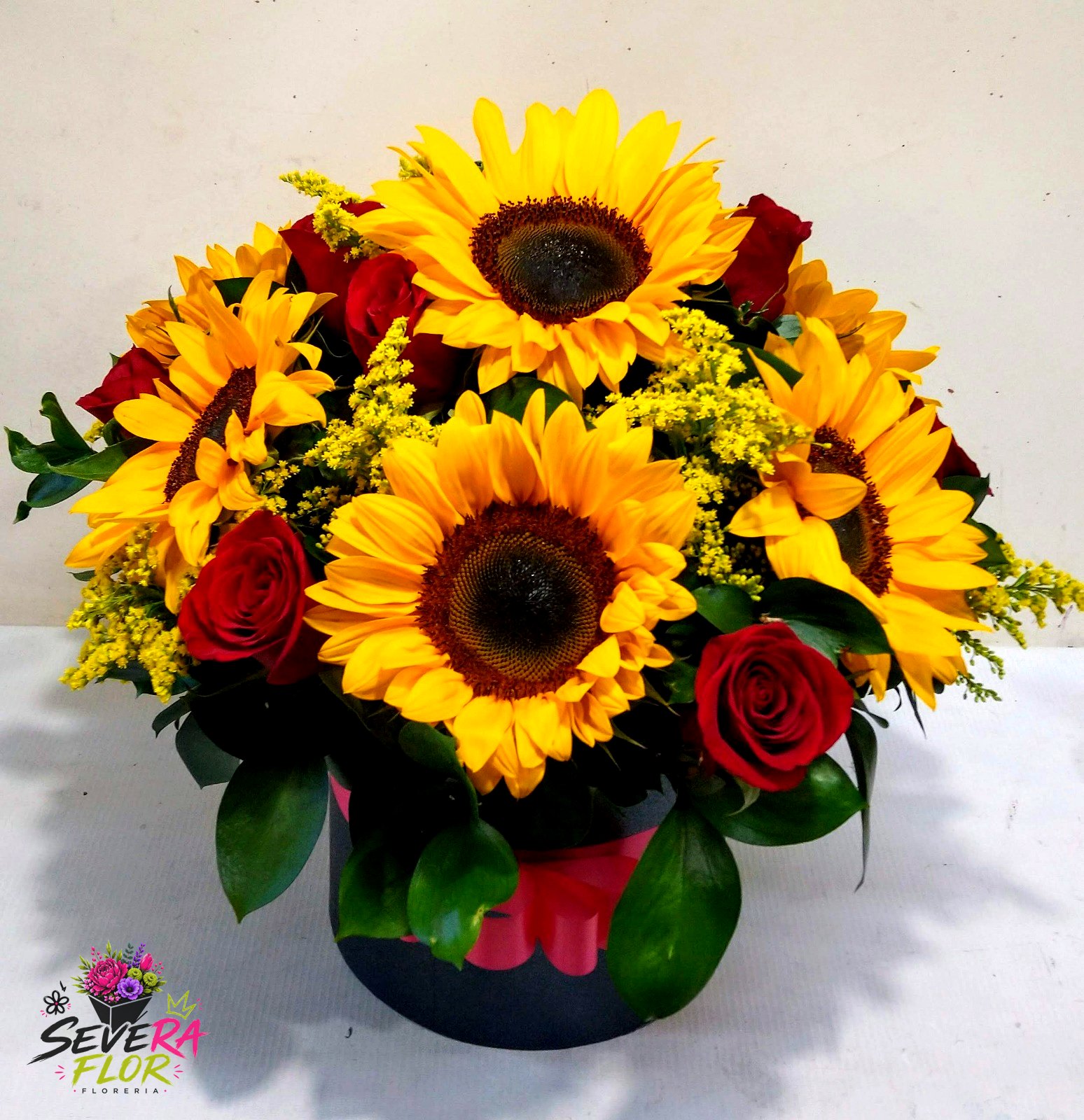 Severo Fuego: Girasoles y rosas rojas en caja oscura. Cajas Florales Severa Flor Bogotá