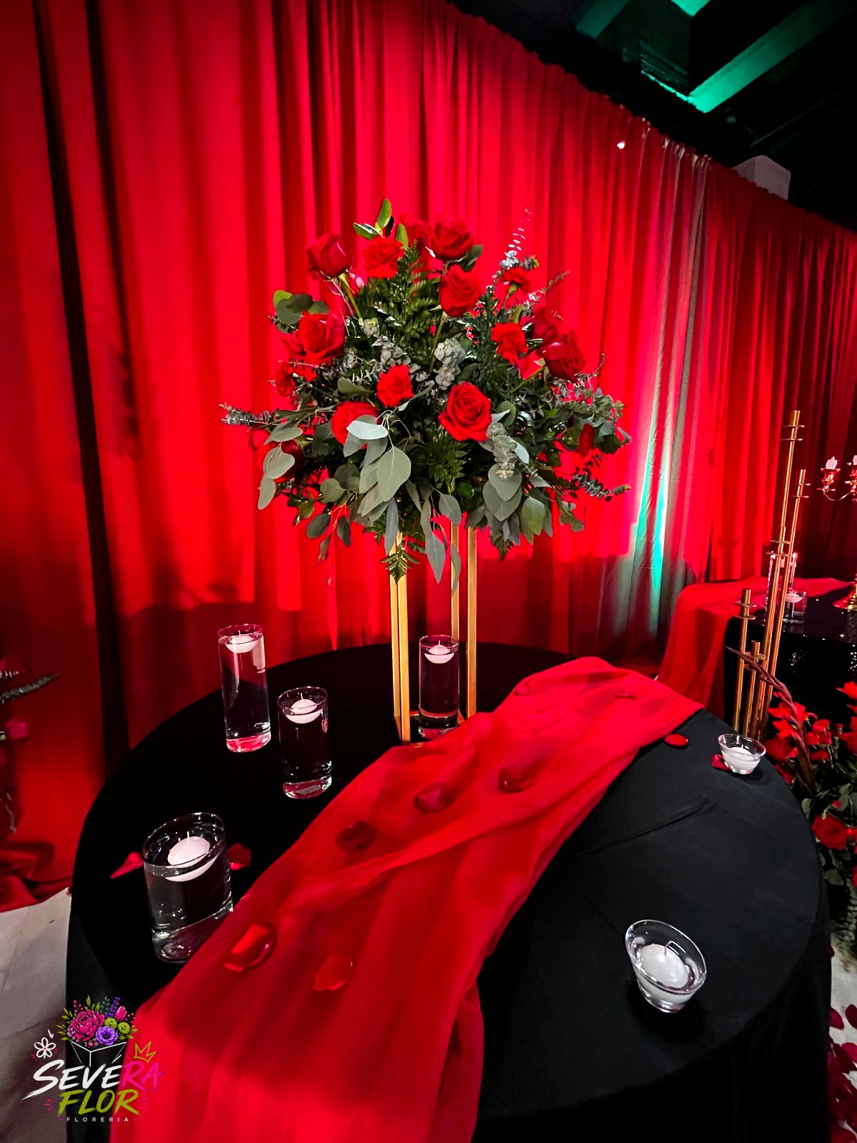 Mesa Principal: Centro de rosas con base metálica y velas flotantes. Eventos Corporativos Severa Flor Bogotá